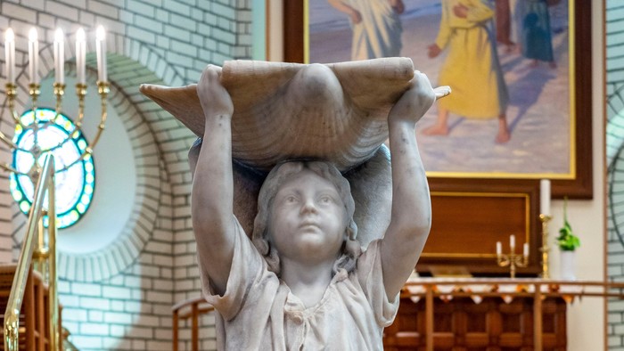 En statue af en engel med vinger i en kirke.