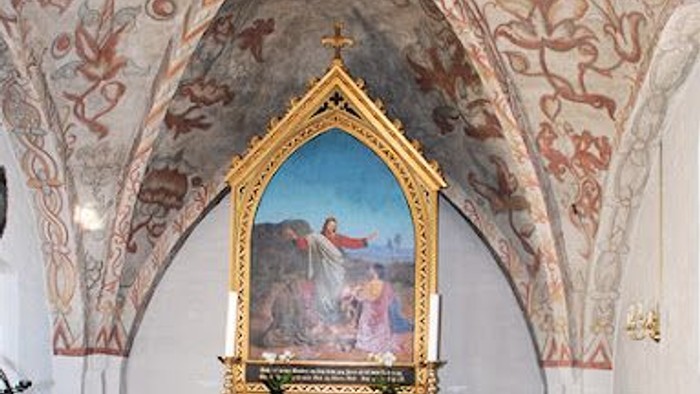 Kirkens indre med malerier og alter.