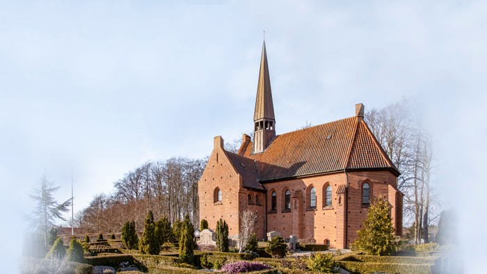 En lille kirke med spir med omgivelser
