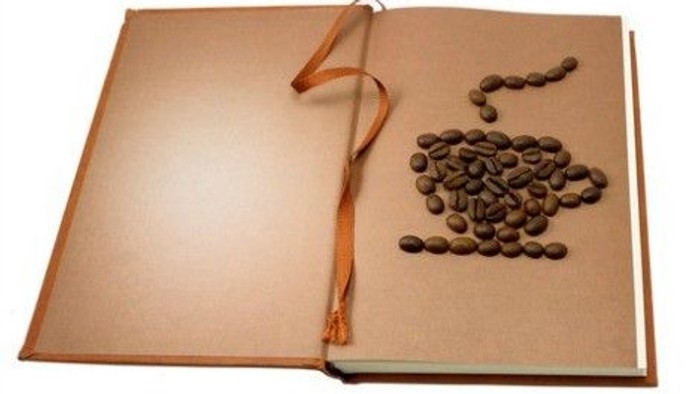 En åben bog med kaffebønner og en rød snor