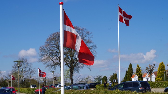 Fire danske flag på stange ved vejside