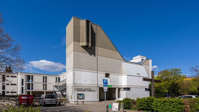 Modernes Gebäude mit Parkplatz und Bäumen im Vordergrund