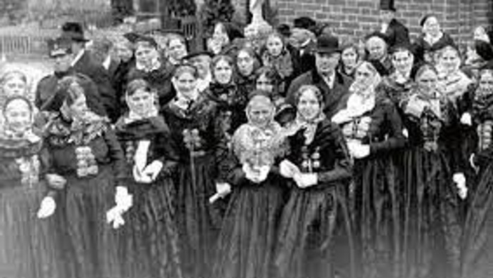 En gruppe børn i festlige tøjer samlet sig til et foto.