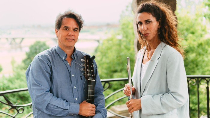 Ein Mann und eine Frau spielen auf einem Balkon Musikinstrumente.