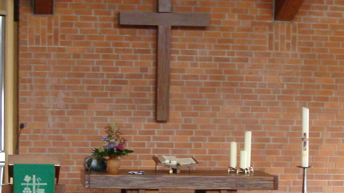 Holzaltar in Kirche mit Kreuz und Kerzen
