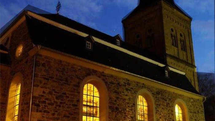 Altes Steinhaus bei Nacht mit beleuchteten Fenstern