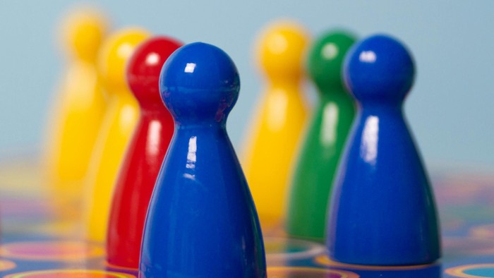 Bunte hölzerne Spielfiguren auf einer gemusterten Oberfläche.