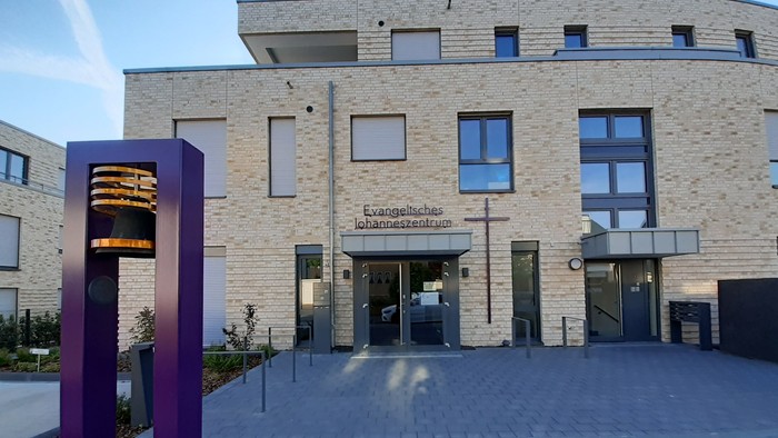 Modernes Gebäude mit großer Glastür und Schriftzug "Evangelisches Krankenhaus"