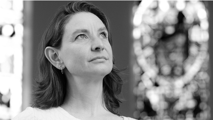 En kvinde med længe hår ser opad i sort-hvid foto.