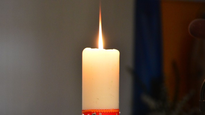 En lysende lysekone med rød bånd om.