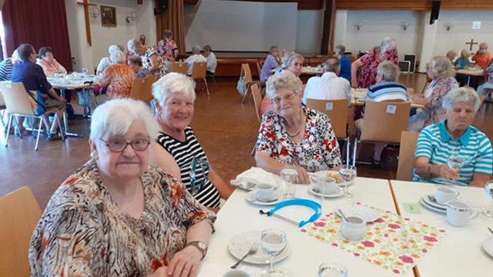 Seniorinnen beim Kaffeetrinken in einem großen Raum