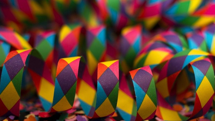 Bunte Konfettischlangen und Konfetti, die in lebendigen, festlichen Mustern verstreut sind.