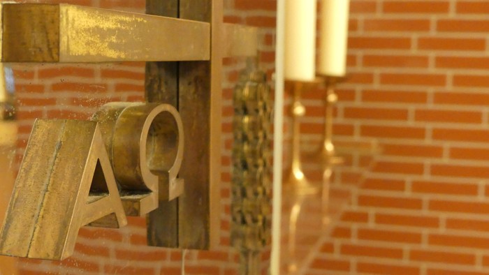 Goldene Buchstaben an Ziegelwand