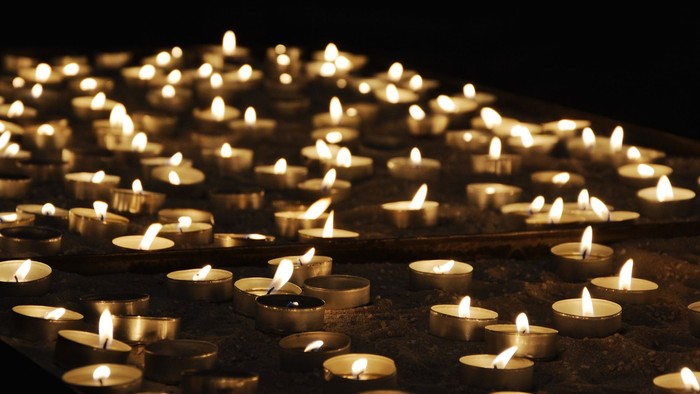 Viele brennende Kerzen in dunkler Umgebung