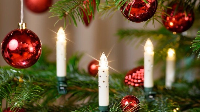 En juletree med røde glaskugler og lysende lysstænger