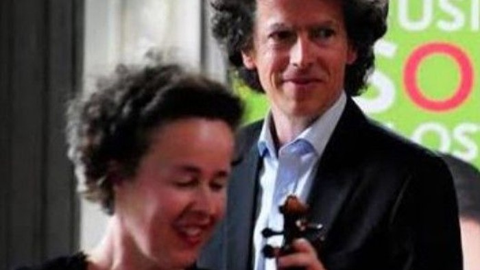 Ein Mann und eine Frau lächeln, er hält eine Geige.