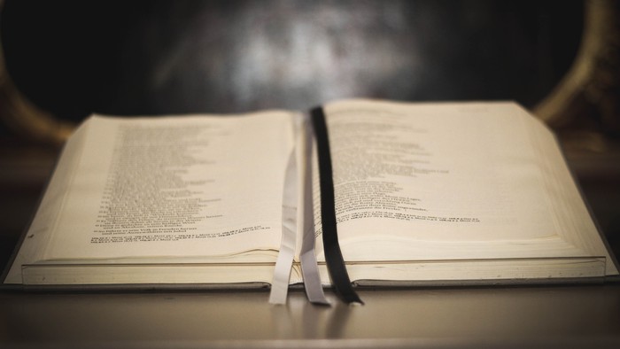 Offenes Buch mit Lesezeichen auf Tisch