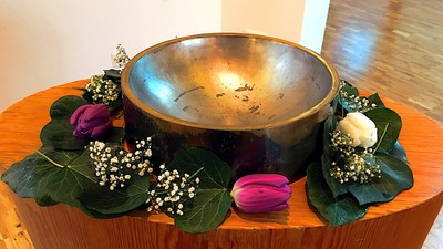 Ovaler Holztisch mit einer Taufschale aus Messing und geschmückten Blumen