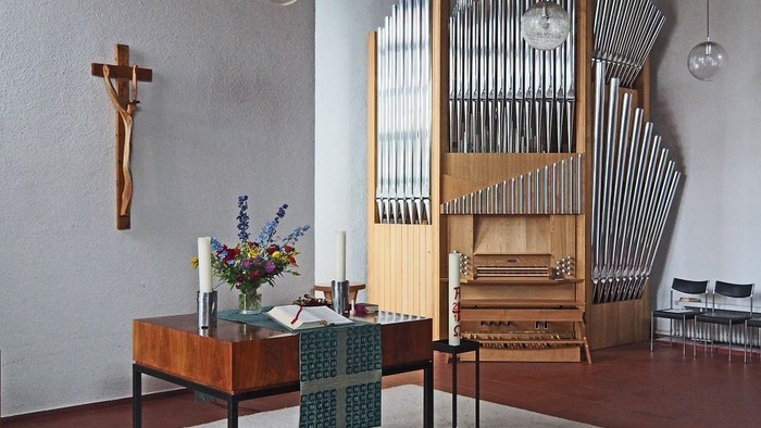 Kircheninneres mit Orgel, Tisch und Kreuz