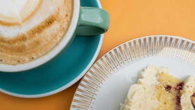 Ein Cappuccino und ein Stück Kuchen auf einem Tisch
