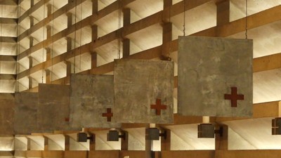 Holzpaneele mit gealterten Steinplatten, die rote Kreuze in einem strukturierten Raster zeigen.