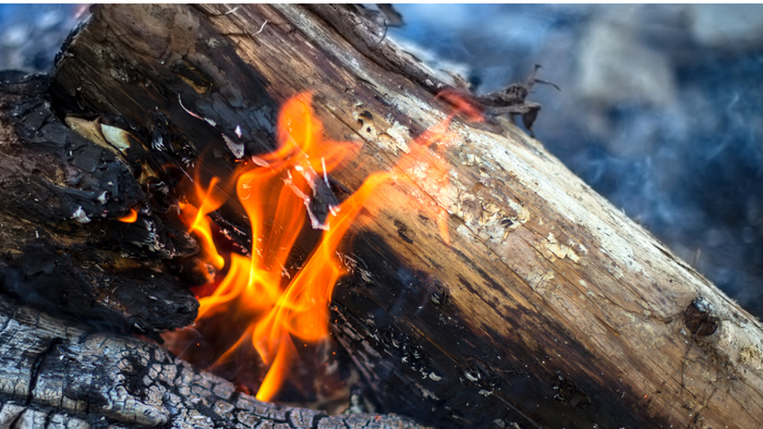 En brennende træstokke i en åbenluft.