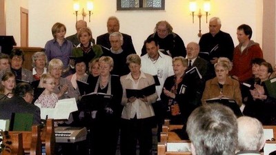 Eine Gruppe von Menschen singt in einem Kirchenraum.