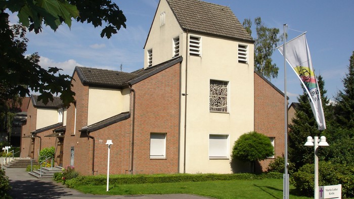 Das Bild zeigt ein zweistöckiges Gebäude mit Ziegelfassade und einem kleinen Turm.