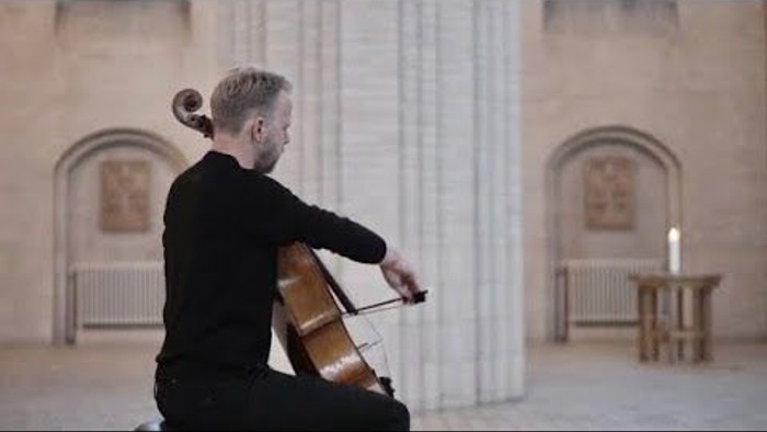 Mand spiller cello i historisk lokalitet.