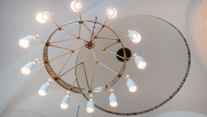 En stor, smuk kæmpelys med mange lysfader hænger fra loftet.