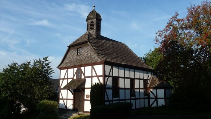 Traditionelles Fachwerkhaus mit kleinem Glockenturm und rustikalem architektonischem Charme.