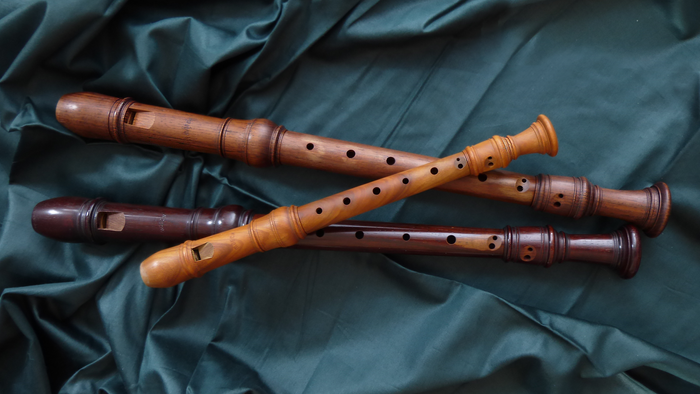 Drei Holzflöten auf blauem Stoff