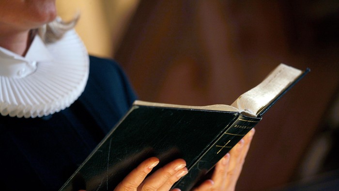 En person læser et håndskrevet bog.