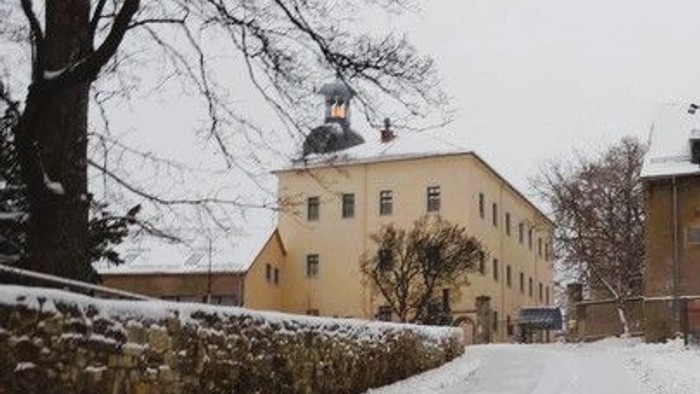 Schneebedeckte Straße vor gelbem Gebäude mit Kuppel.