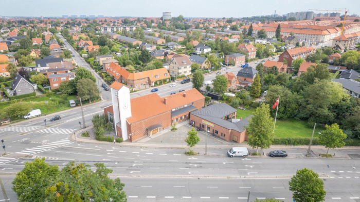 En stor by med mange røde tagtegn og en stor kirke i midten