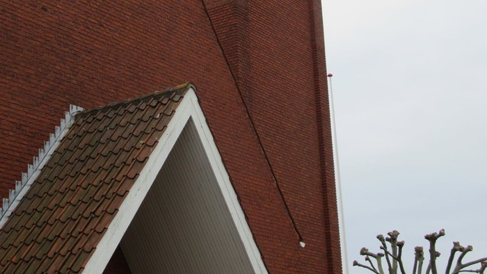 Røde mursten og sorte vinduer på højhus.