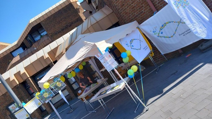 Mehrere Sonnenschirme mit bunten Punkten vor einem Gebäude