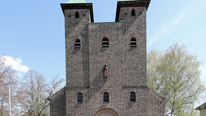Das Bild zeigt eine alte Kirche mit zwei Türmen und Kreuzspitzen.