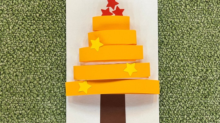 Weiße Pappkarte mit weihnachtlichem Baummotiv beklebt