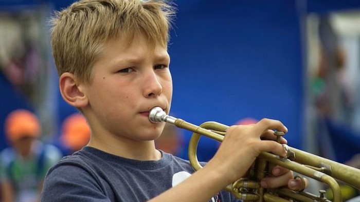 Ein Junge spielt auf der Trompete.