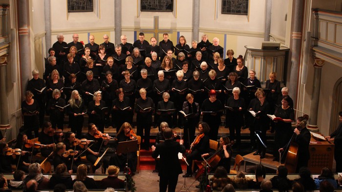 Ein großer Chor und Orchester proben in einer Kirche