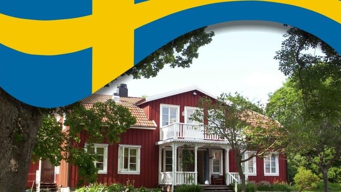 Ein rotes Holzhaus mit weißer Veranda und Garten, mit schwedischer Flagge.