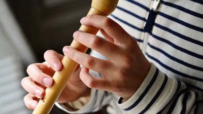 Kind spielt mit gelben Stöcken