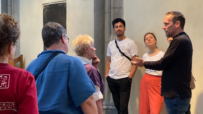 Eine Gruppe von Menschen steht in einem Raum und unterhält sich.