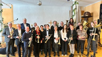 Ein Orchester posiert mit Instrumenten in einem Raum