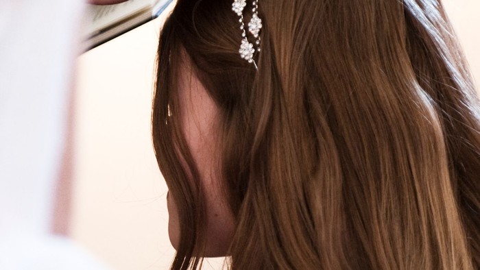 En kvinde med lang, brun hår og en smykke i håret.