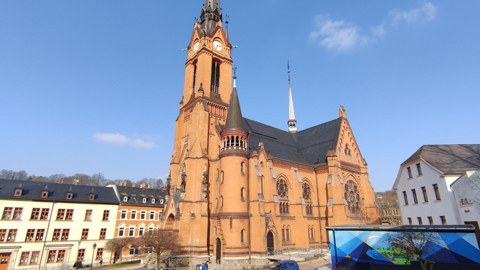 Große Kirche mit hohem Turm in Stadtmitte, umgeben von Wohngebäuden