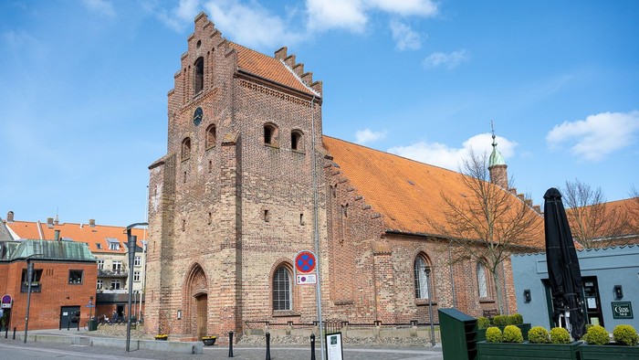 Gamle kirke med teglmur og spistegning i bymiljø