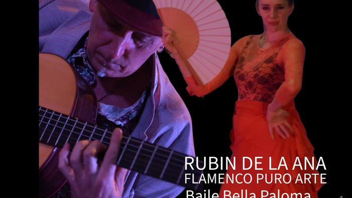 Ein Mann spielt Gitarre, während eine Frau in rotem Kleid tanzt und ein Fächer hält