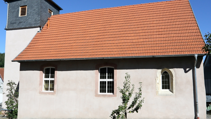 Kleine Kirche mit rotem Dach und kleiner Kuppel.